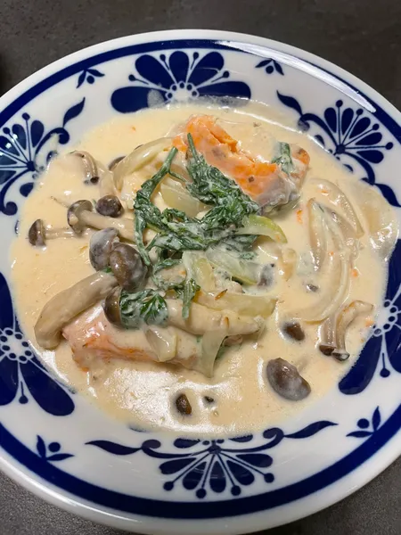 鮭・玉ねぎ・しめじのクリームシチューに、刻んだにんじんの葉をのせた