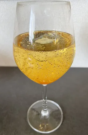 梅シロップをワイングラスに注ぎ、炭酸水で割った