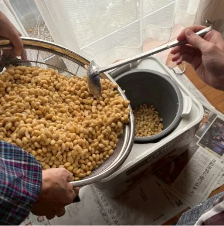 餅つき機に大豆を入れる