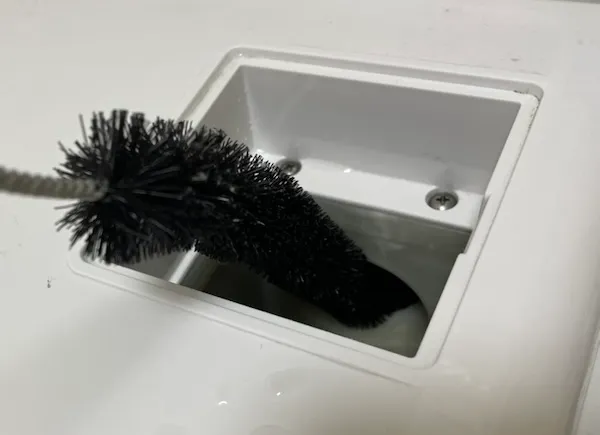 ブラシで乾燥ダクト内のホコリを掻き出す