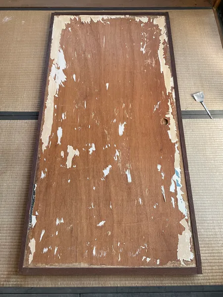 古い紙をはがしてベニヤが出たふすま