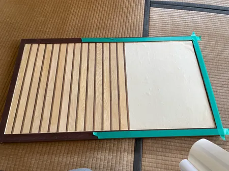 古い紙の上から木目調の壁紙シールを半分まで貼った天袋