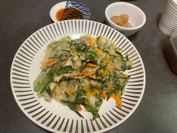 皿に盛ったニラとにんじんのチヂミと、タレを入れた小皿