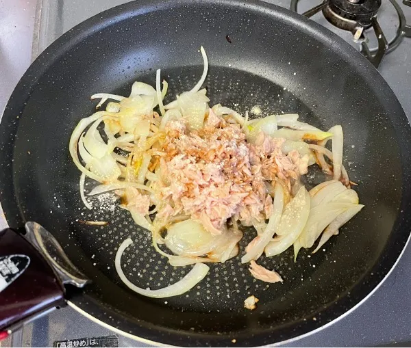 玉ねぎがしんなりしたら、ツナ缶・醤油・鶏ガラスープ粉末を加えてさらに炒める。