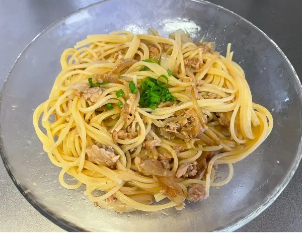 茹で上がったパスタをザルにあけ、具材と混ぜ合わせる。お好みでネギをのせて完成！