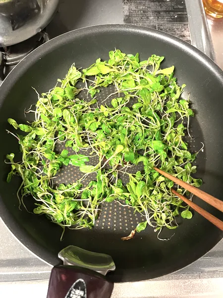 フライパンで間引き菜を炒めているところ